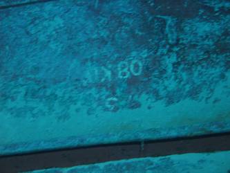 Large section of hull in debris field with "08KO" painted on plating